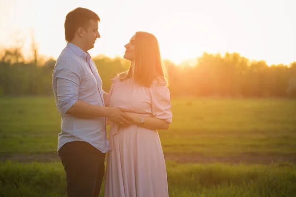 Jeune couple enceinte dans un parc de printemps — Photo