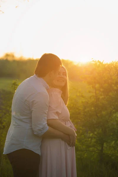 Pareja embarazada joven en un parque de primavera — Foto de Stock