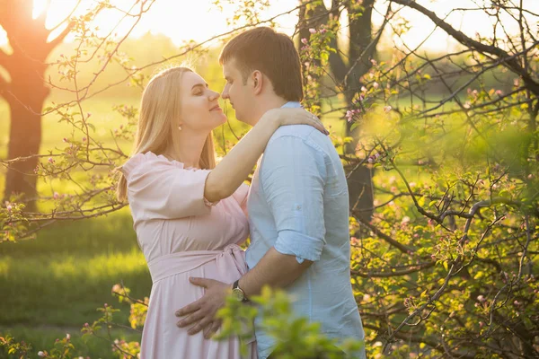 Unga gravida par i en spring park — Stockfoto