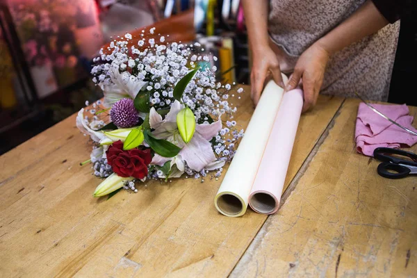 Fiorista confezioni un mazzo di fiori — Foto Stock
