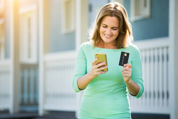 Mujer sosteniendo teléfono inteligente y tarjeta de crédito — Foto de Stock