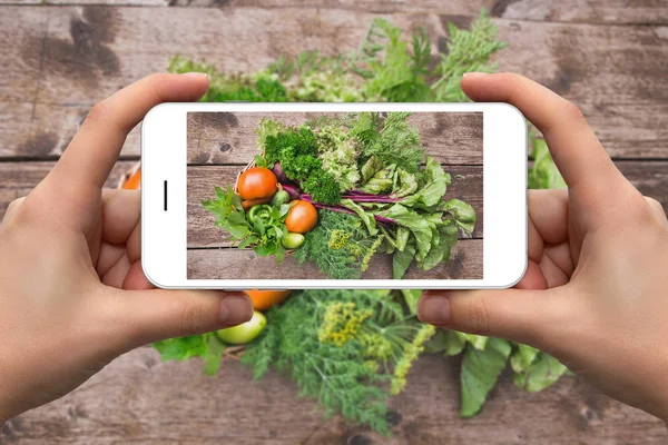 Woman taking picture of vegetables