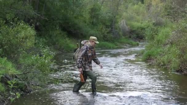 Hunter crossing through river — Stock Video