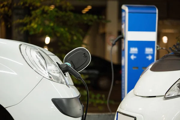 Electric car charged on a charging station in a indoor parking — Stock Photo, Image