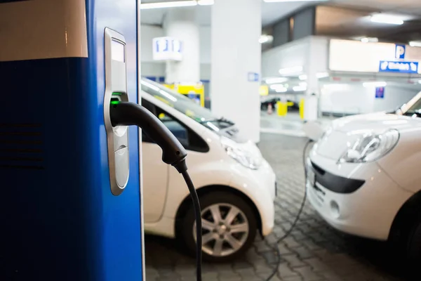 Samochód elektryczny na stację ładującą w kryty parking — Zdjęcie stockowe