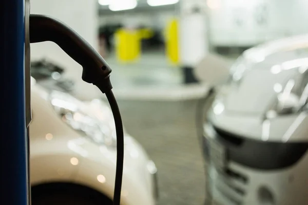 Coche eléctrico cargado en una estación de carga en un aparcamiento cubierto —  Fotos de Stock