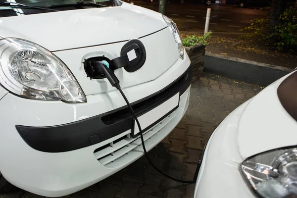 Carro elétrico carregado em uma estação de carregamento em um estacionamento interno — Fotografia de Stock