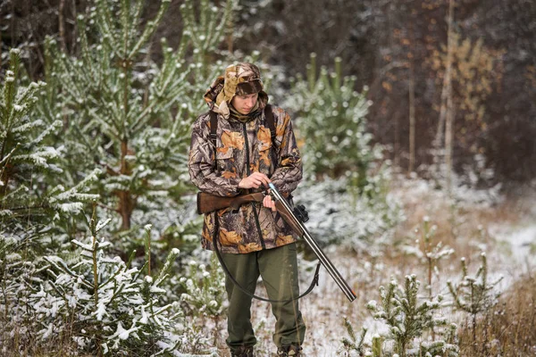 Chasseur avec un sac à dos et un fusil de chasse dans la forêt d'hiver . — Photo