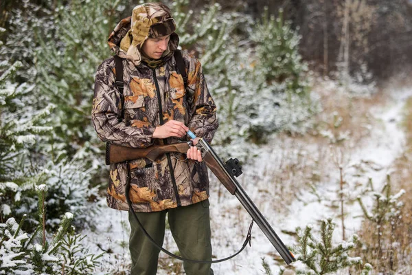 Охотник с рюкзаком и охотничьим ружьем в зимнем лесу . — стоковое фото