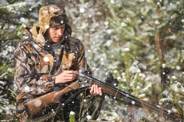 Chasseur avec un sac à dos et un fusil de chasse dans la forêt d'hiver . — Photo