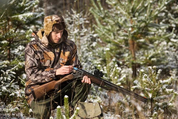 Bir sırt çantası ve bir av silahı kış ormandaki Avcı. — Stok fotoğraf