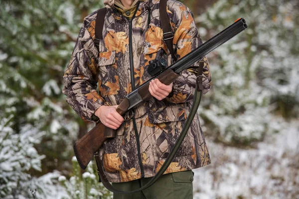 Hunter con una mochila y un arma de caza en el bosque de invierno . — Foto de Stock