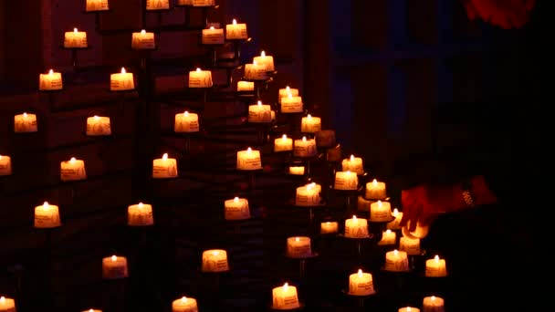 Man sätter ljus på piedestal i kyrkan — Stockvideo