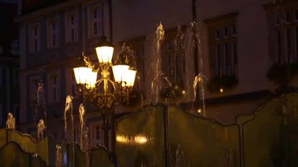 Fuente de la ciudad salpicaduras cerca de linternas — Vídeo de stock