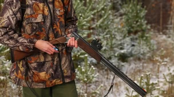 Охотник заряжает охотничье ружье в лесу — стоковое видео