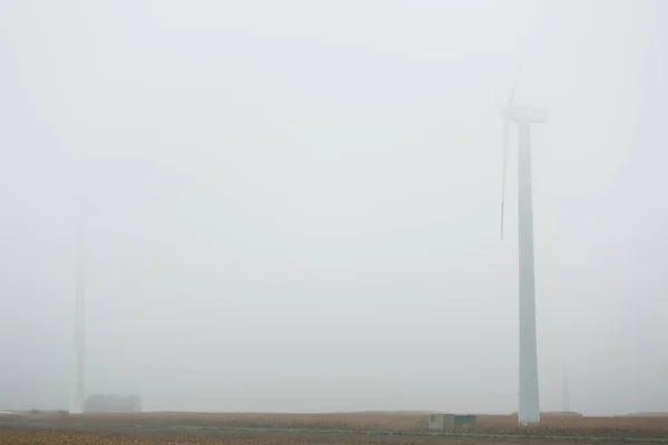 Industriella vindkraftverk i dimma. — Stockfoto