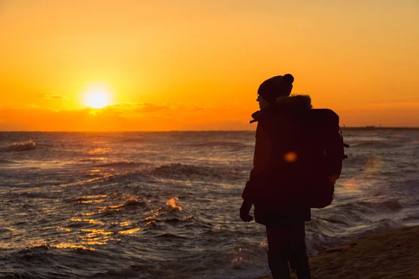 Een reiziger met een rugzak staat aan de oever van de Japanse zee — Stockfoto