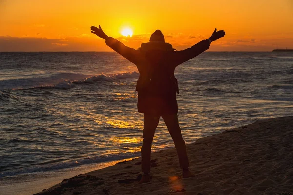 Man reiziger met een rugzak staat op het strand — Stockfoto