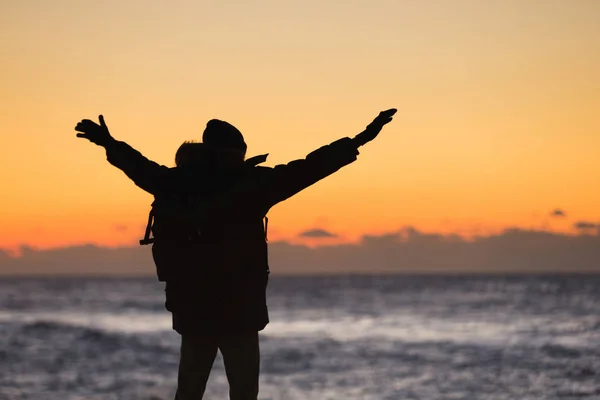 Man reiziger met een rugzak staat op het strand — Stockfoto