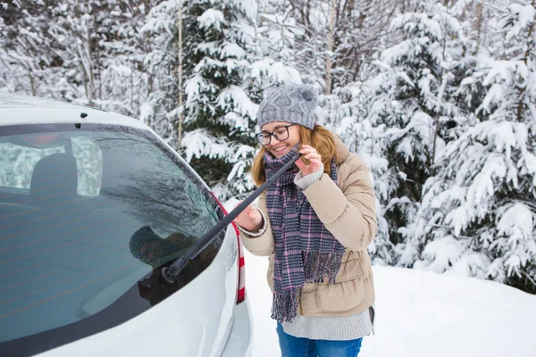 Jonge vrouw stuurprogramma is het reinigen van de Wisser van een auto. — Stockfoto