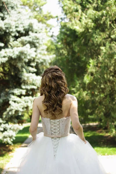 Bride in a summer sunny park. — Stock Photo, Image