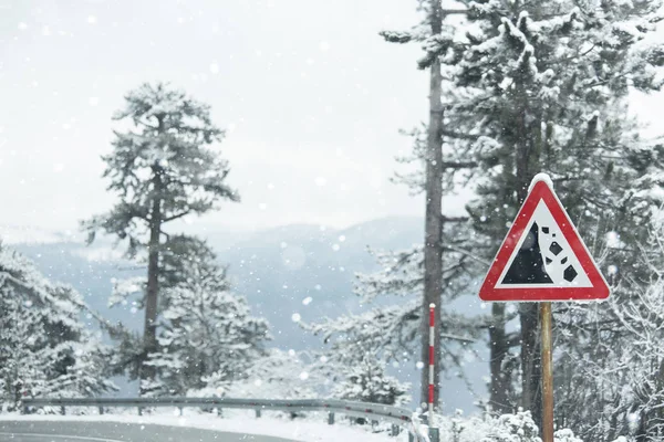 Гірська зимова дорога з попереджувальним знаком — стокове фото