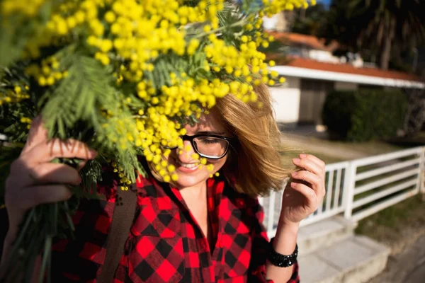 Donna felice con un mazzo di fiori gialli mimosa . — Foto Stock