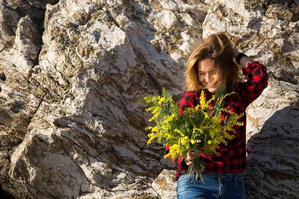 Portrait d'une femme tenant un bouquet de fleurs de mimosa . — Photo