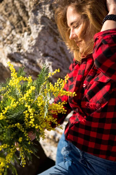 Porträt einer Frau mit einem Strauß Mimosen. — Stockfoto