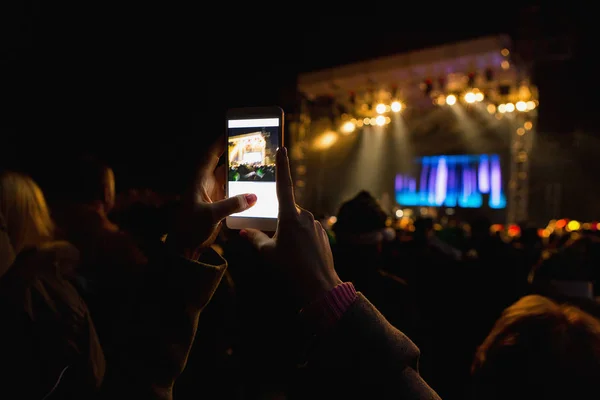 Uma menina está tirando fotos no telefone . — Fotografia de Stock