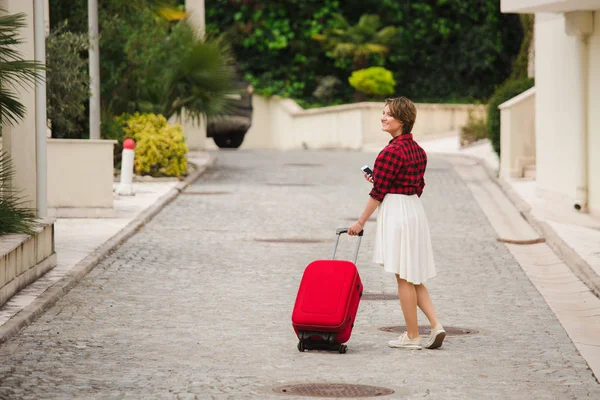 Viajero joven con una maleta y teléfono — Foto de Stock
