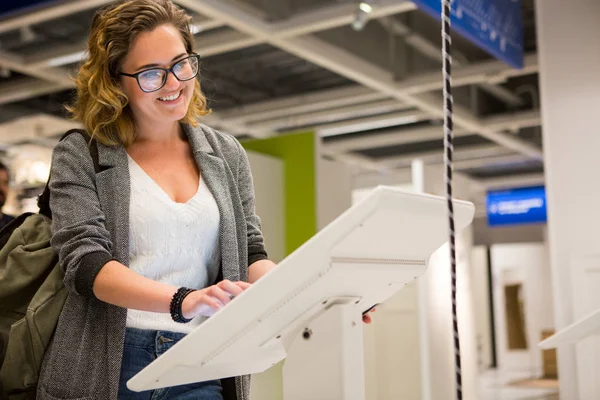 Femme avec dispositif libre-service dans le magasin — Photo