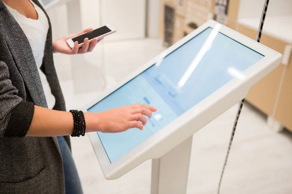 A woman touching the screen of self service device — Stock Photo, Image