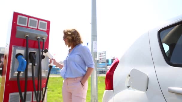 Uśmiechnięta Kobieta Ładowania Samochodów Elektrycznych Kobieta Ładowanie Samochodów Elektrycznych Ciągu — Wideo stockowe