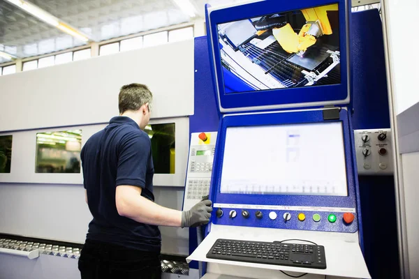 Bediener steuert Maschine zum Schneiden von Metall. — Stockfoto