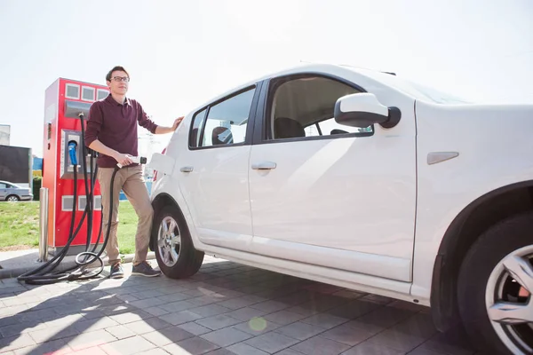 A man stands at the charging station — Stock Photo, Image