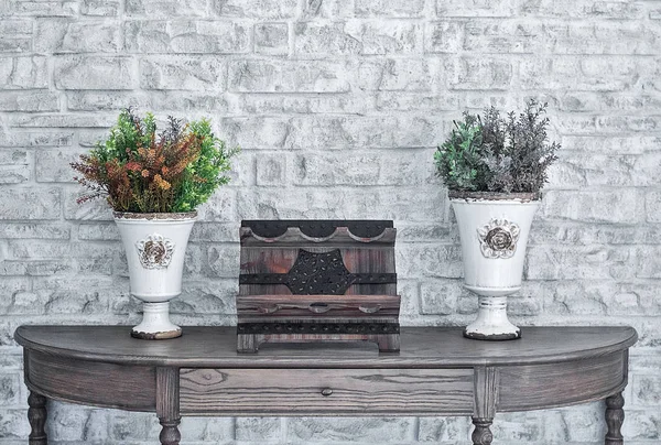 Moderne junge Zimmer Interieur Holzschreibtisch mit Attrappe und Blumen dekorieren, moderne weiße Backsteinwand. — Stockfoto