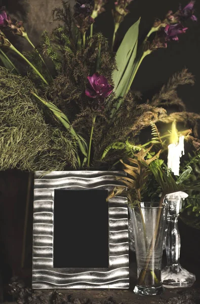 Vintage Fotorahmen und Blumen auf Holztisch über Grunge-Hintergrund Stillleben — Stockfoto