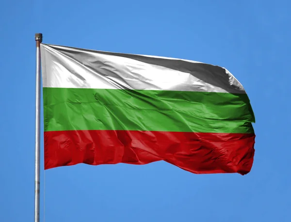 National flag of Bulgaria on a flagpole in front of blue sky