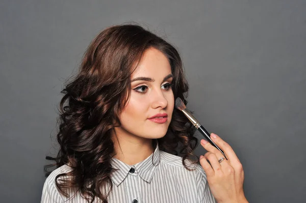 Jonge mooie brunette meisje in de salon make-up — Stockfoto