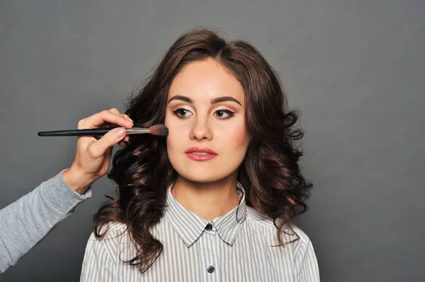 Jonge mooie brunette meisje in de salon make-up — Stockfoto