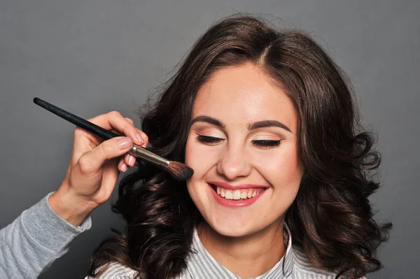 Jonge mooie brunette meisje in de salon make-up — Stockfoto