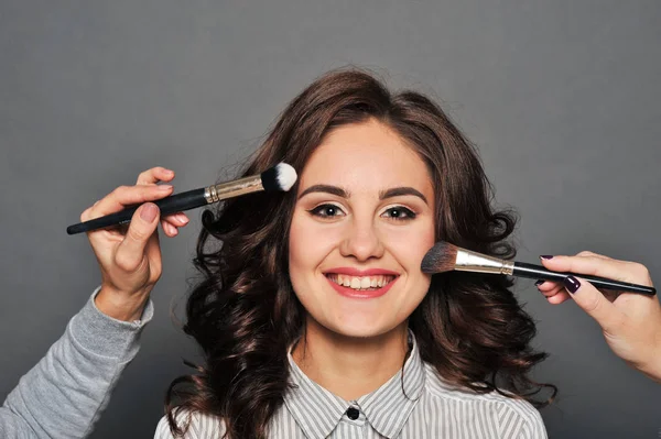 Jonge mooie brunette meisje in de salon make-up — Stockfoto
