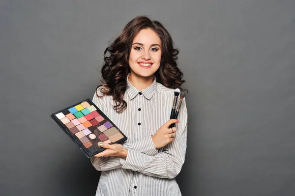 makeup artist paints a very pretty brunette