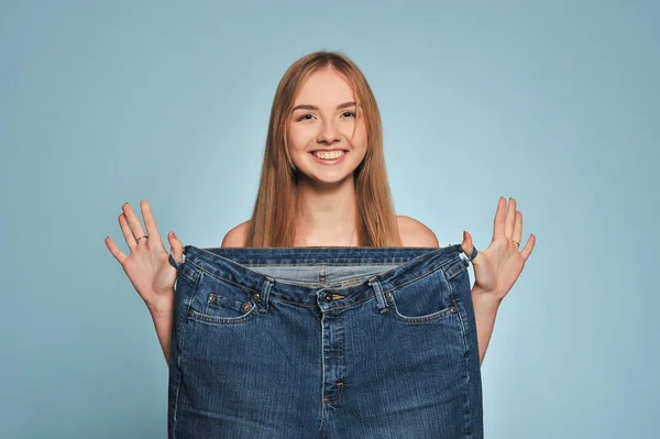 Fit young woman in loose jeans