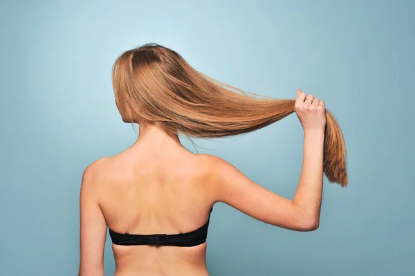 Девушка в черном лифчике показывает свои длинные волосы — стоковое фото