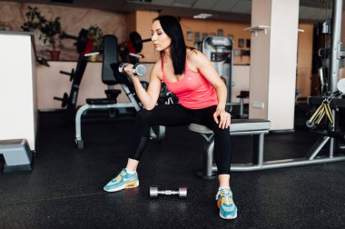 Sportif kız dumbbells ile egzersiz yaparak.