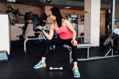 Sportif kız dumbbells ile egzersiz yaparak.