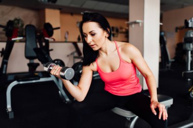 Sportif kız dumbbells ile egzersiz yaparak.