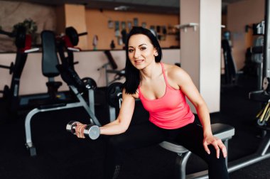 Sportif kız dumbbells ile egzersiz yaparak.